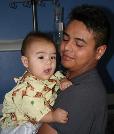 Father holding his baby in a hospital room.
