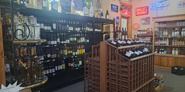 Wine and liquor store interior with shelves and racks full of bottles.