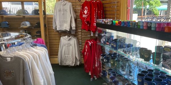 Clothing and souvenir mugs displayed in a gift shop.