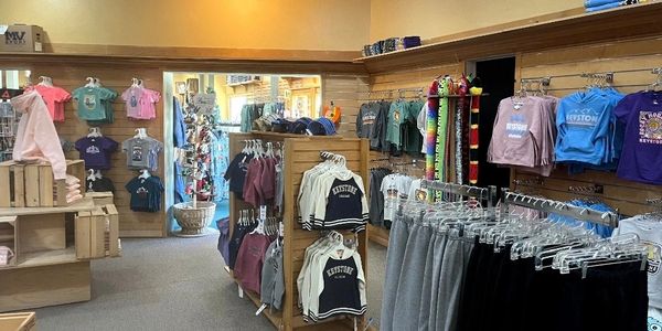 Clothing store interior displaying casual apparel and sweatshirts on racks and walls.
