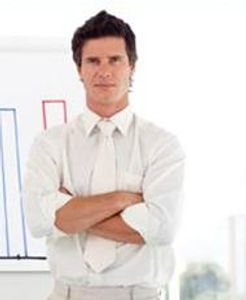 A man with brown hair, wearing a white shirt and white tie