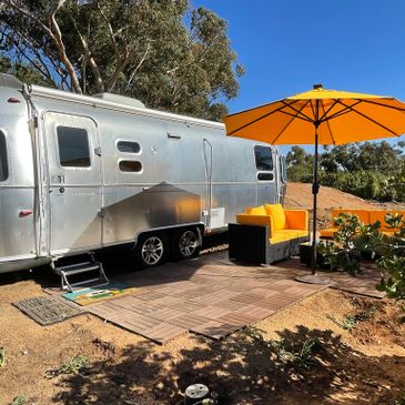 An Airstream travel trailer and a yellow umbrella 
