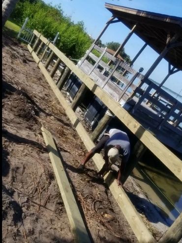 Workers installing dock on lakeside shoreline