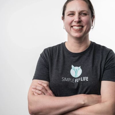 Amity Farr, woman with brown hair, smiling and wearing a Simple Fly Life tshirt.