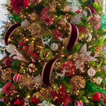 A beautifully decorated Christmas tree with lights, ribbons, and ornaments.