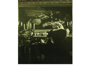 Victorian-era woman in black dress poses solemnly in an ornate room.
