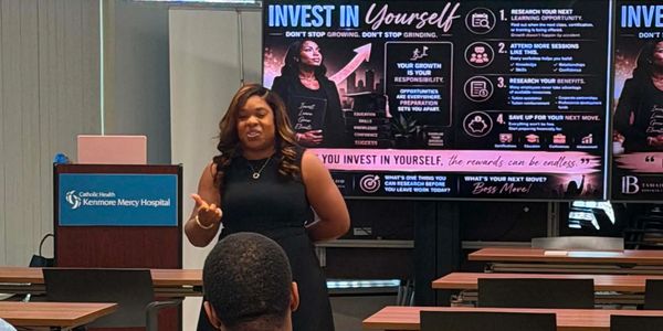 Woman speaking in front of a wellness presentation.