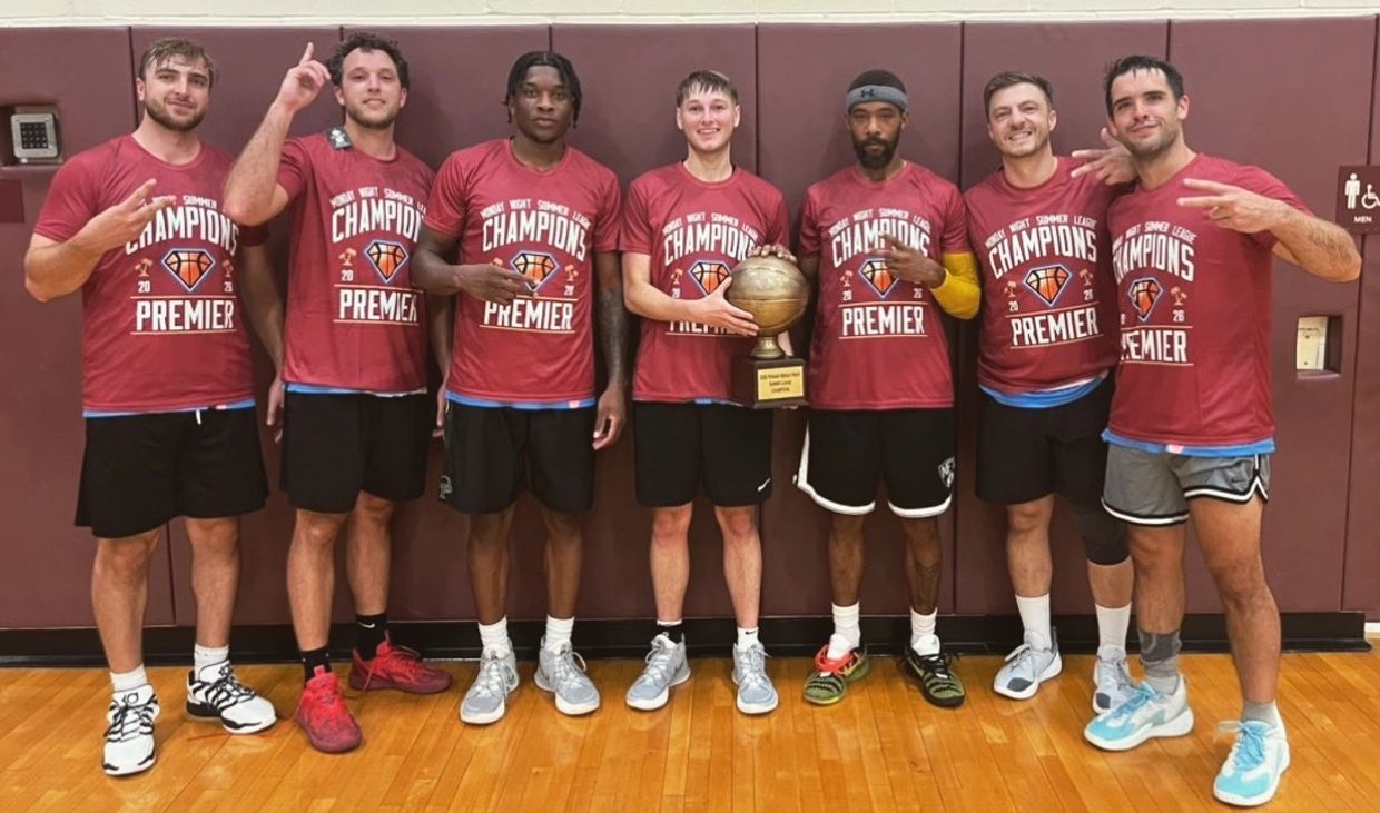 Basketball team celebrating championship win with trophy.