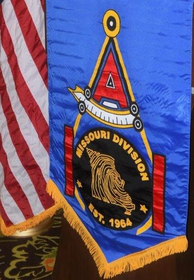 Banner for Missouri Division, established 1964, with American flag beside it.