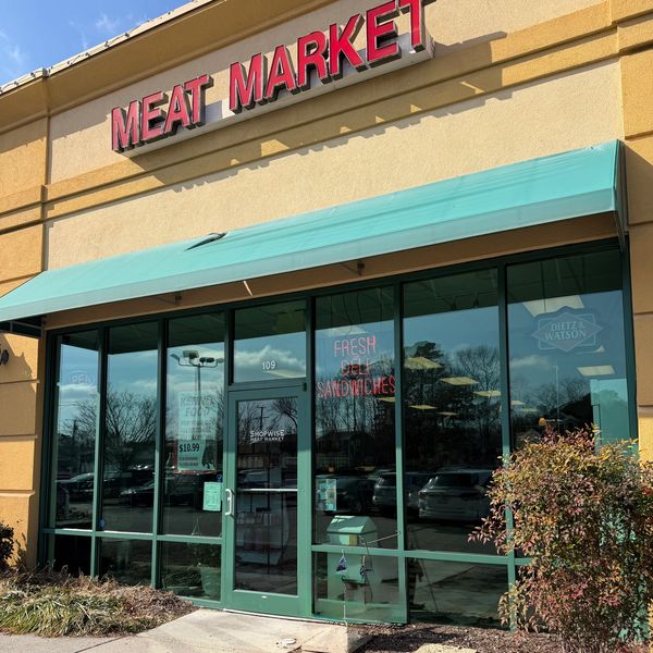 Front of store with large sign above that says Meat Market