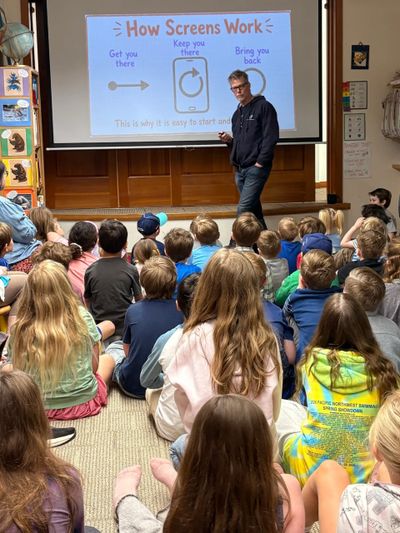 A man teaches children about how screens work in a classroom setting.