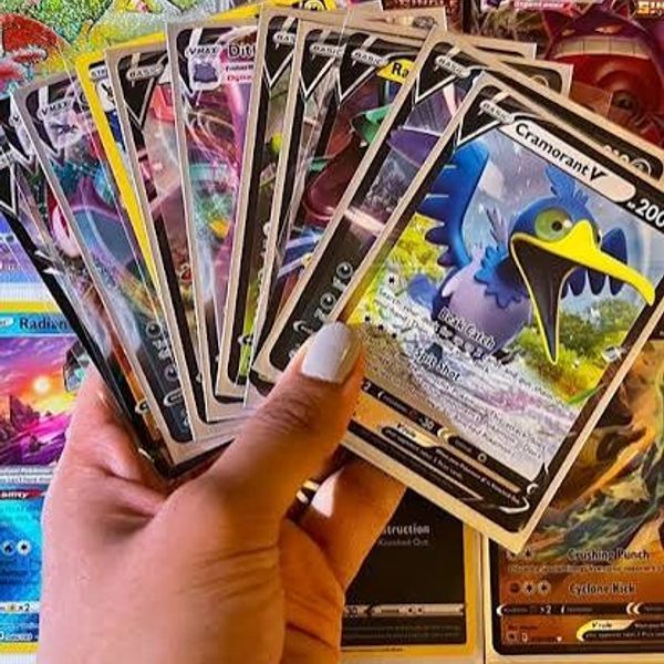 Hand holding a fan of Pokémon trading cards.