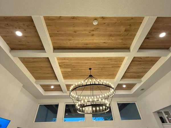 Elegant wooden coffered ceiling with a large circular chandelier.