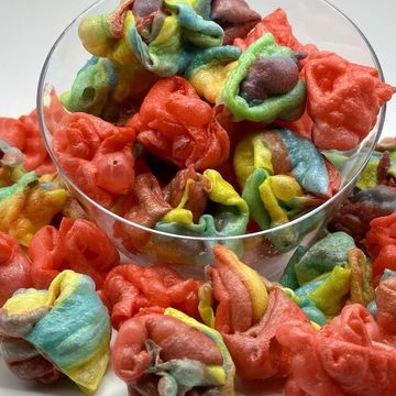 Colorful rainbow popcorn in a clear bowl.