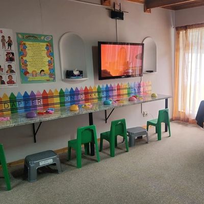 Children's study room with colorful decorations and drinks table.