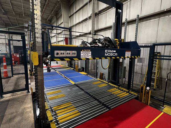 Industrial conveyor system with rollers and colored mats in a warehouse.
