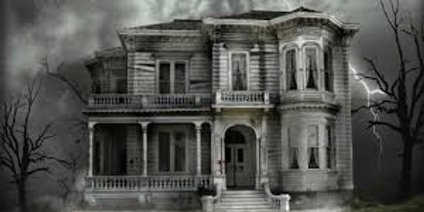 Spooky old Victorian house with lightning and barren trees.