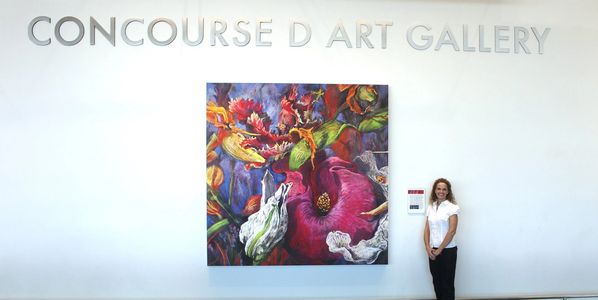 The artist, Gayle Mangan Kassal, standing with her print of River Dance at BWI airport.