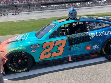 NASCAR race car #23 with vibrant teal and orange colors on the track.