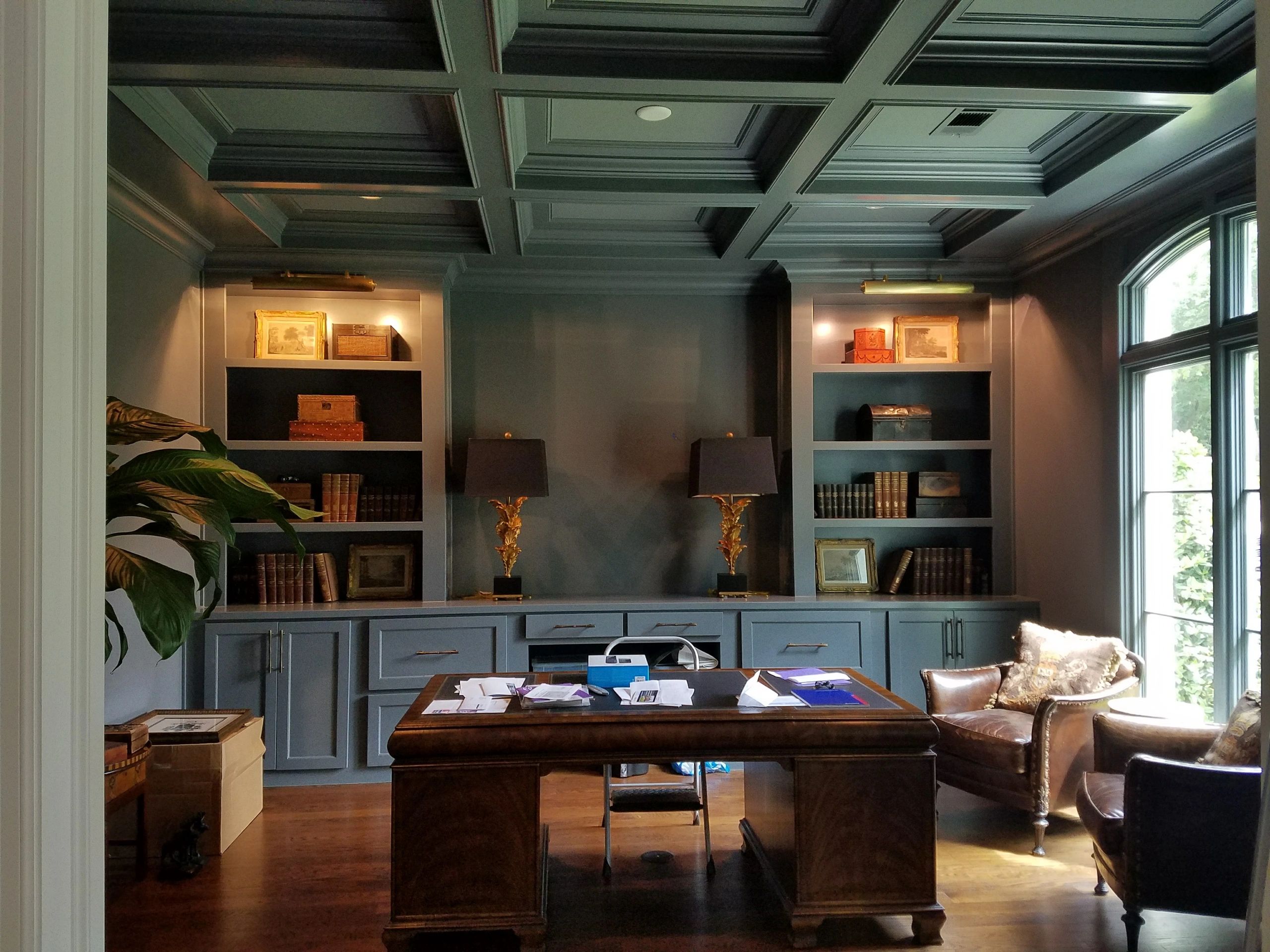 Elegant home office with dark wood furniture and built-in shelves.