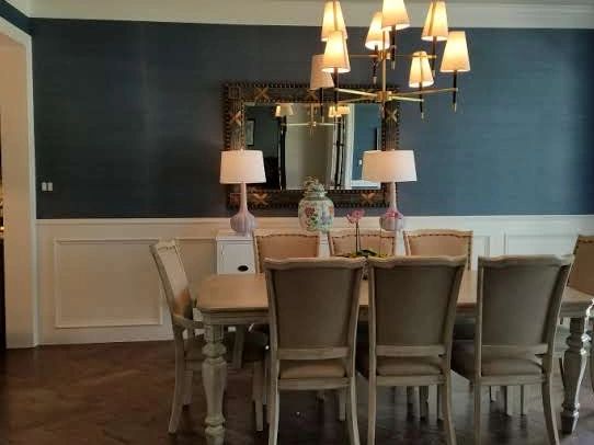 Elegant dining room with a large wooden table and beige chairs.