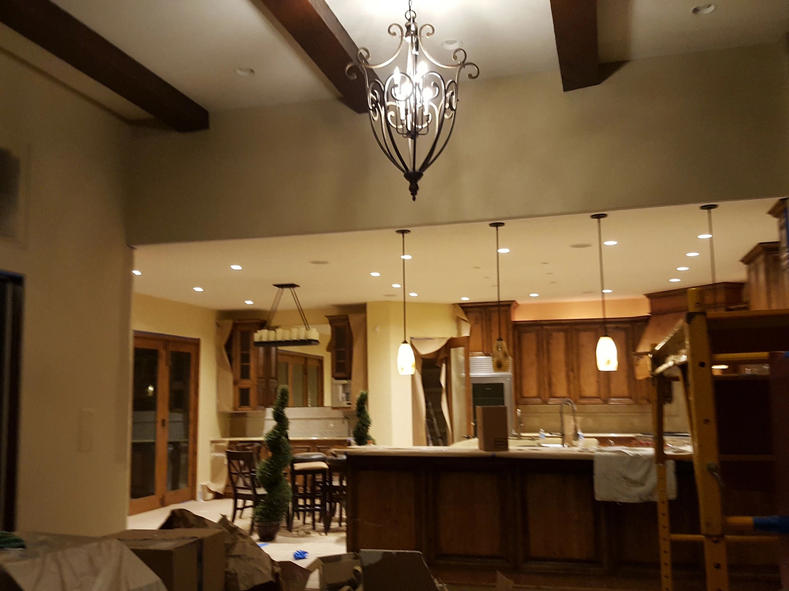 A warmly lit kitchen with wooden cabinets and decorative lighting fixtures.
