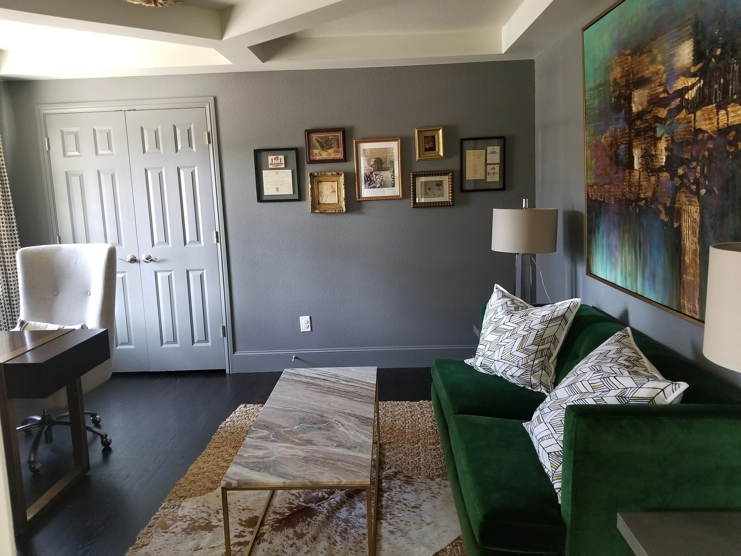 Modern living room with gray walls and green couch.