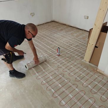 Man installing electric floor heating mats.