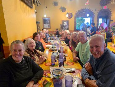 Large group enjoying a meal together at a colorful Mexican restaurant.