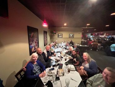 Large group gathered around a table in a cozy restaurant.