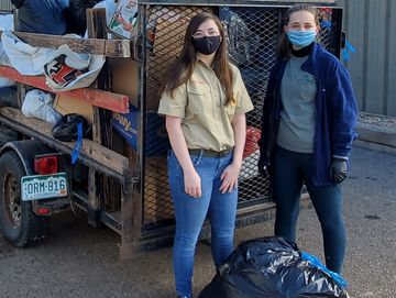 Two Scouts deliver HOPE clothing donations in plastic bags. 2020 - in masks.