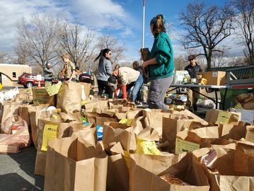 Donation bags sit on the ground while volunteers empty and sort them.