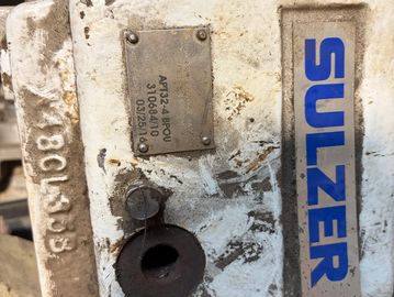 Close-up of a Sulzer machinery part with metal plate and serial number.