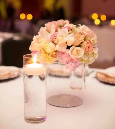 Elegant floral centerpiece with a floating candle on a soft-lit table.