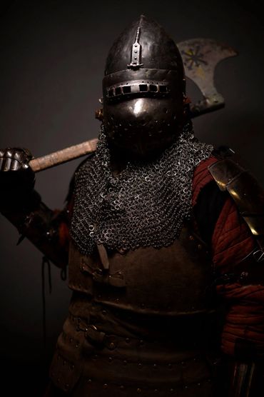 Medieval knight in full armor holding a battle axe.