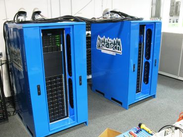 Two blue Nor-Tech supercomputers with visible cables and server racks.