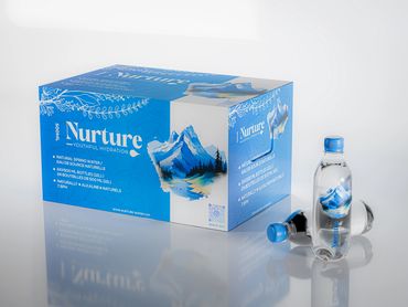 Box and bottles of Nurture natural spring water with mountain design.