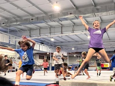Kids joyfully jumping and playing in an indoor gymnasium.