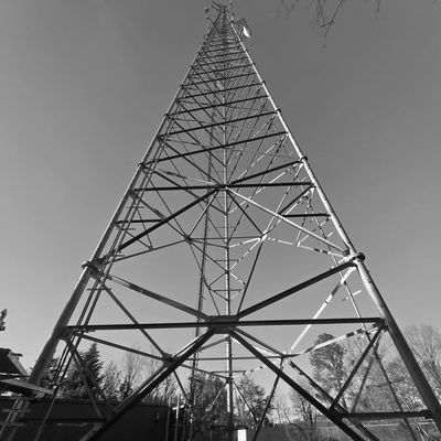 Tall metal communication tower against a clear blue sky.