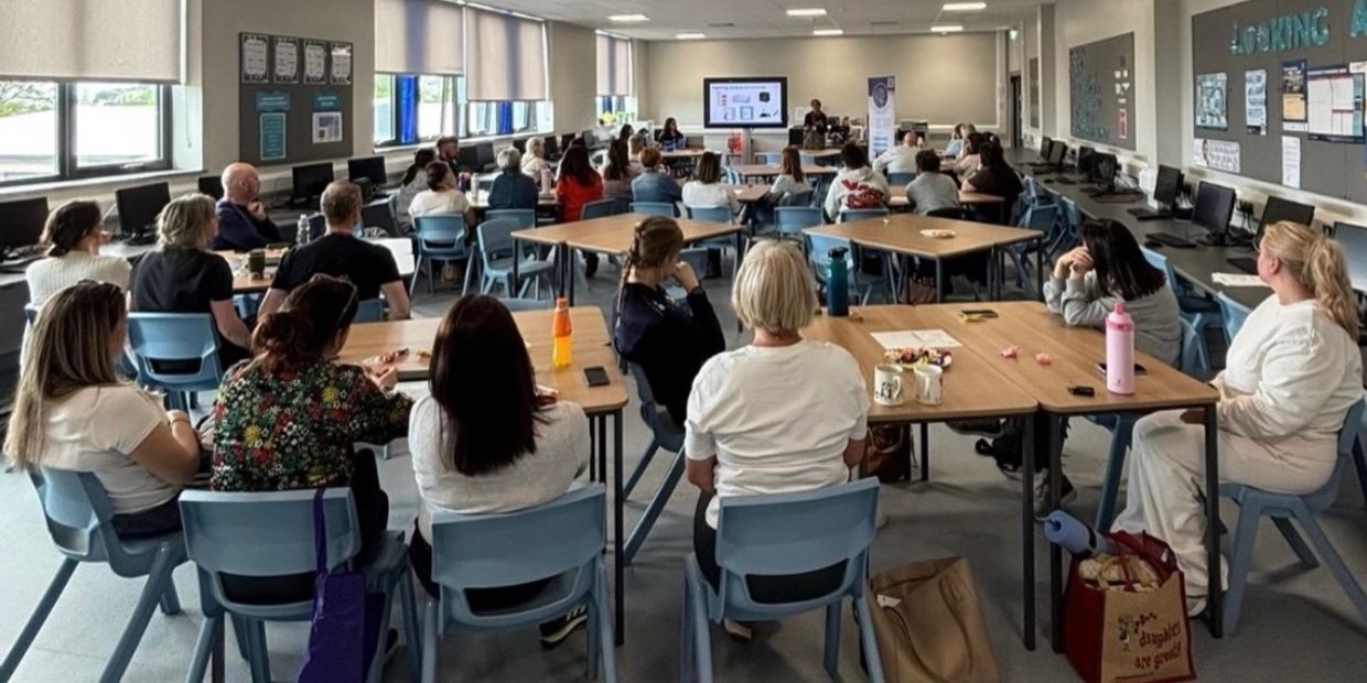 A classroom filled with adults attending a lecture.