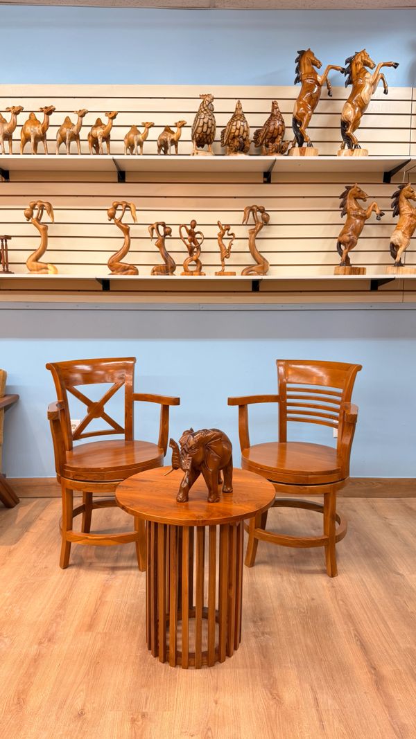 Wooden chairs, table, and animal carvings in a cozy room.
