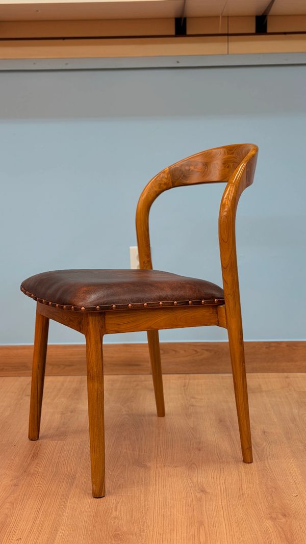 Wooden chair with a curved backrest and leather seat cushion.