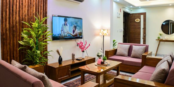 Cozy living room with wooden furniture and plants.