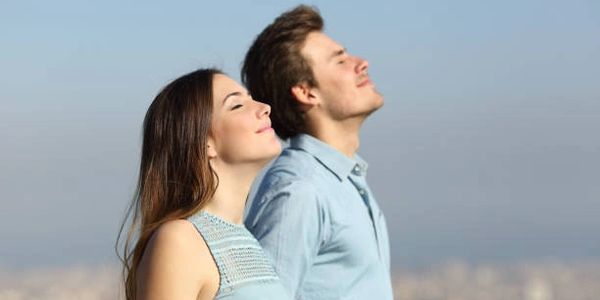 2 personas al aire libre respirando el aire fresco, deteniéndose un momento a apreciar el sol.