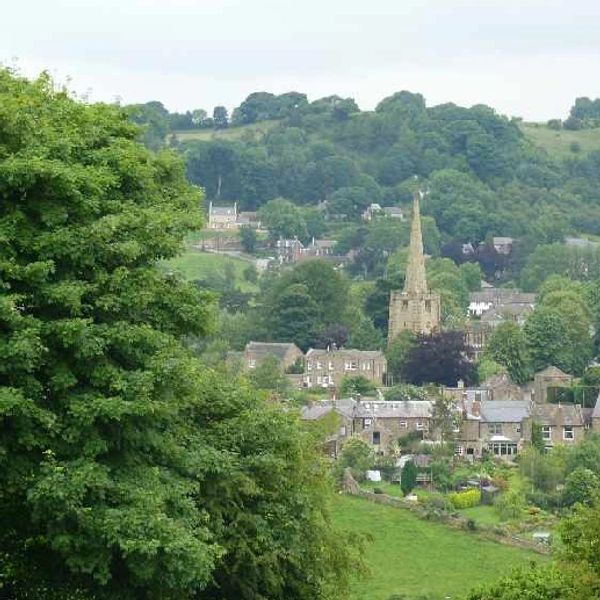A quaint village surrounded by lush green hills and trees.