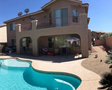 Completed stucco repair on a two-story house with a smooth, freshly painted finish.