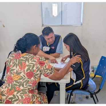 Three people engaged in a focused discussion over a document at a small table.