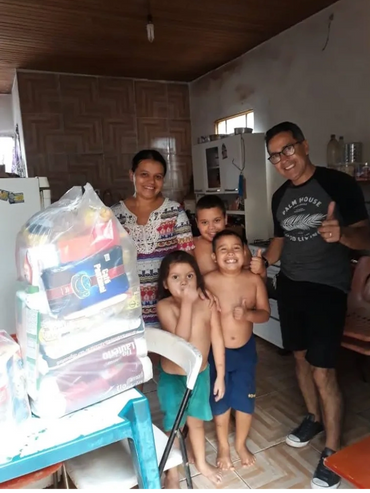 Happy family posing indoors with groceries and smiles.