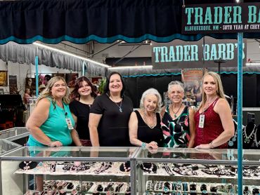 Six women standing behind a jewelry display at Trader Barb's booth.