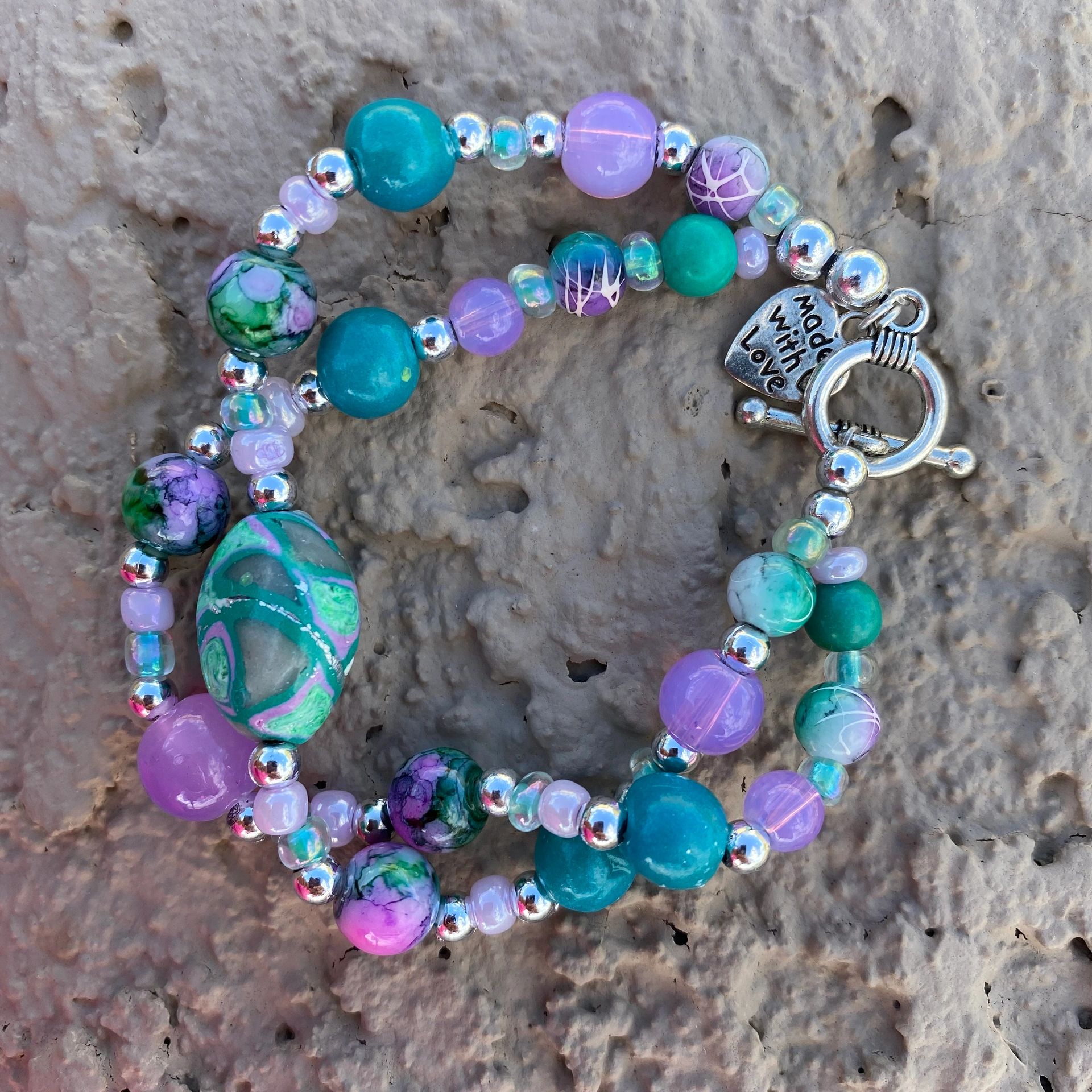 This item has complimenting greens, blues and purples,including handcrafted beads from clay.
